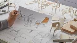 设计师正拿着铅笔为椅子设计产品草图